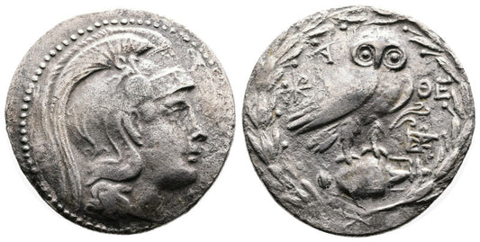 Two ancient greek  silver tetradrachm coins with a portrait of athena on one side and an owl on the other