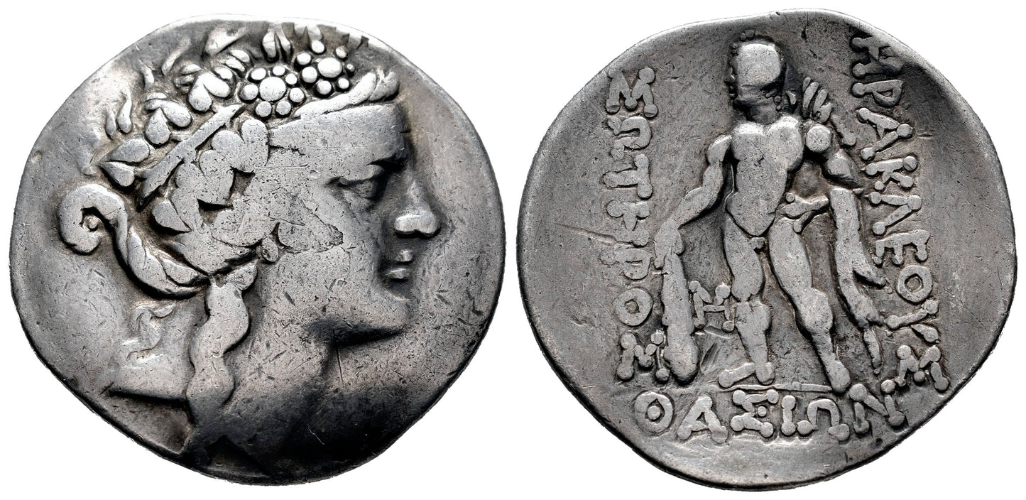 front and back Ancient coin with a Dionysus on one side and text  and heracles on the other, set against a white background.