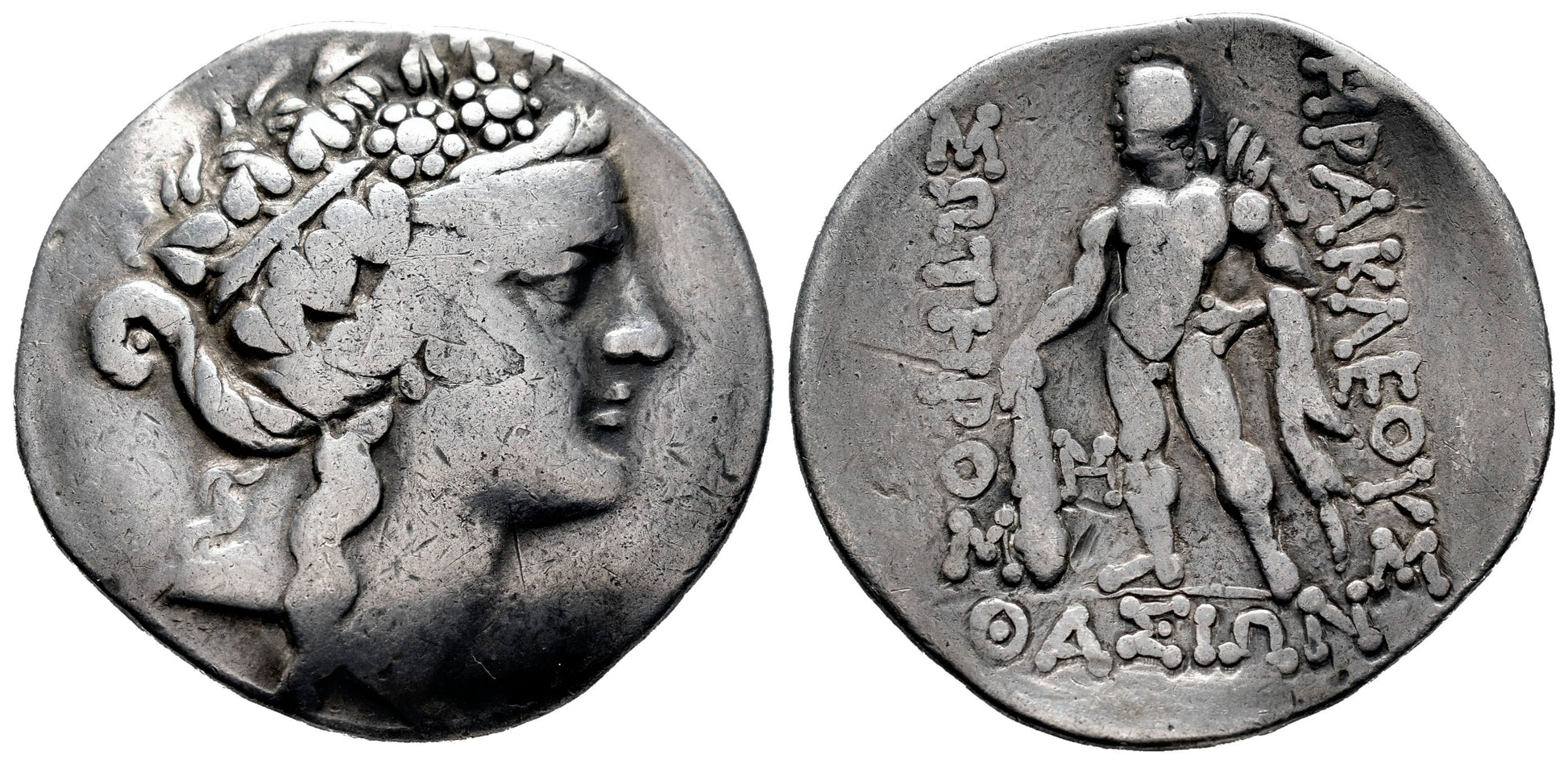 front and back Ancient coin with a Dionysus on one side and text  and heracles on the other, set against a white background.